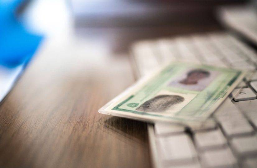 Uma mesa com um teclado e uma identidade desfocada sob o teclado