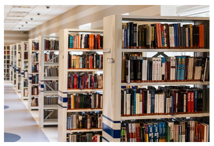 A imagem mostra varias estantes de ferro cheias de livros em um corredor