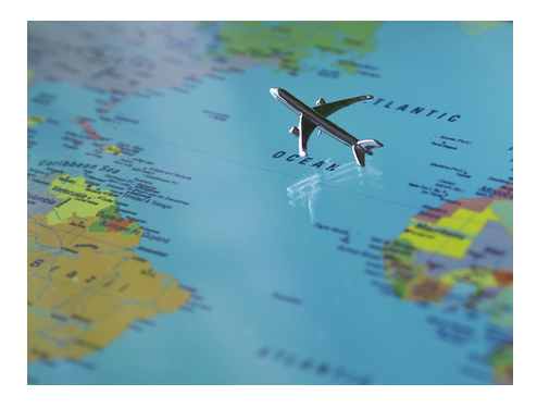 A imagem mostra um pequeno avião de metal sobre uma tela que mostra uma imagem em zoom de um mapa mundi